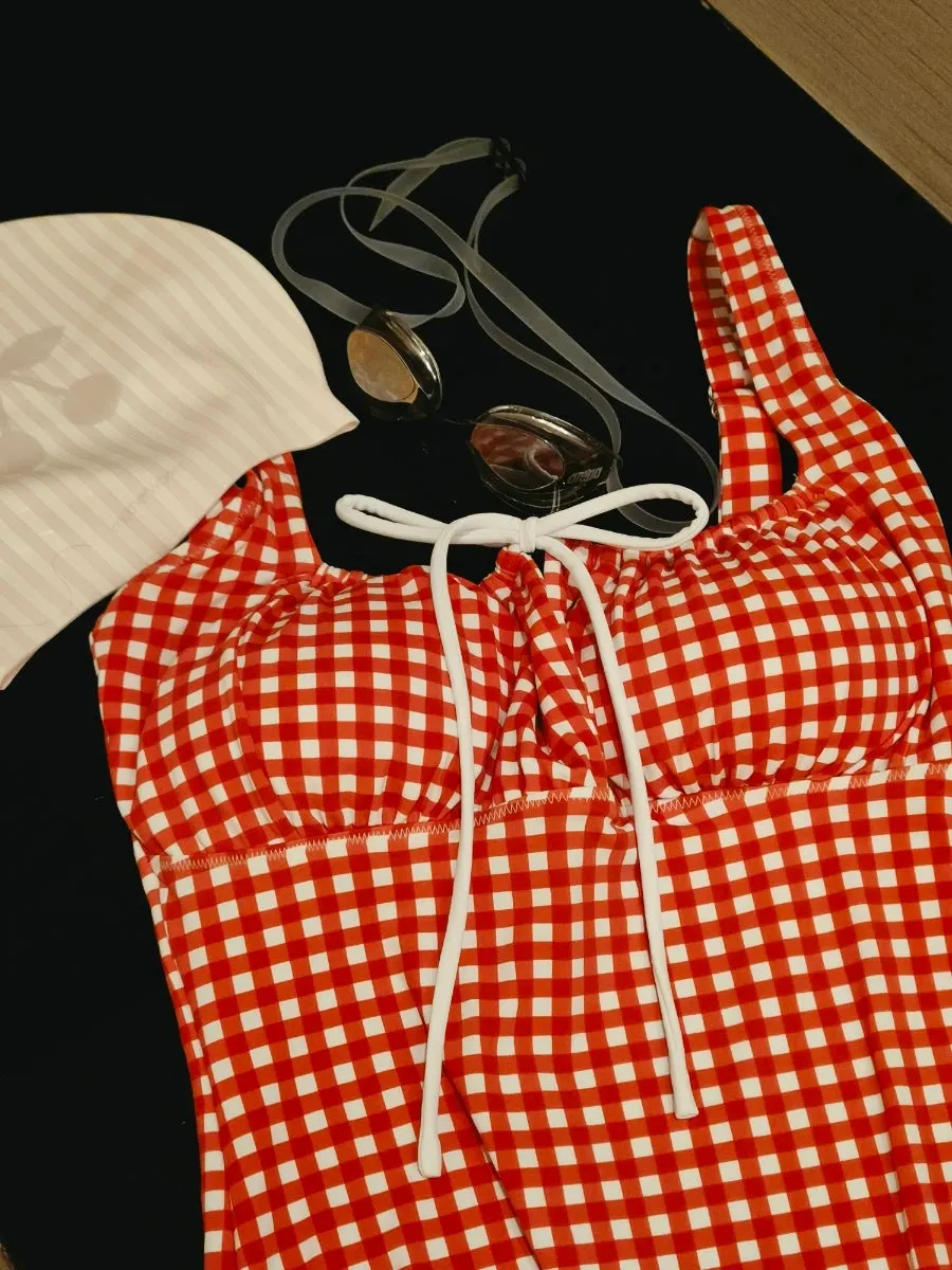 Red gingham one-piece swimsuit worn underwater in a pool