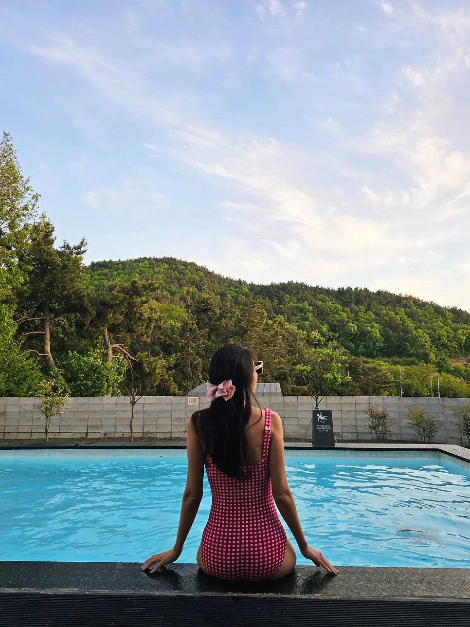 Check one-piece swimsuit worn on a pool villa trip