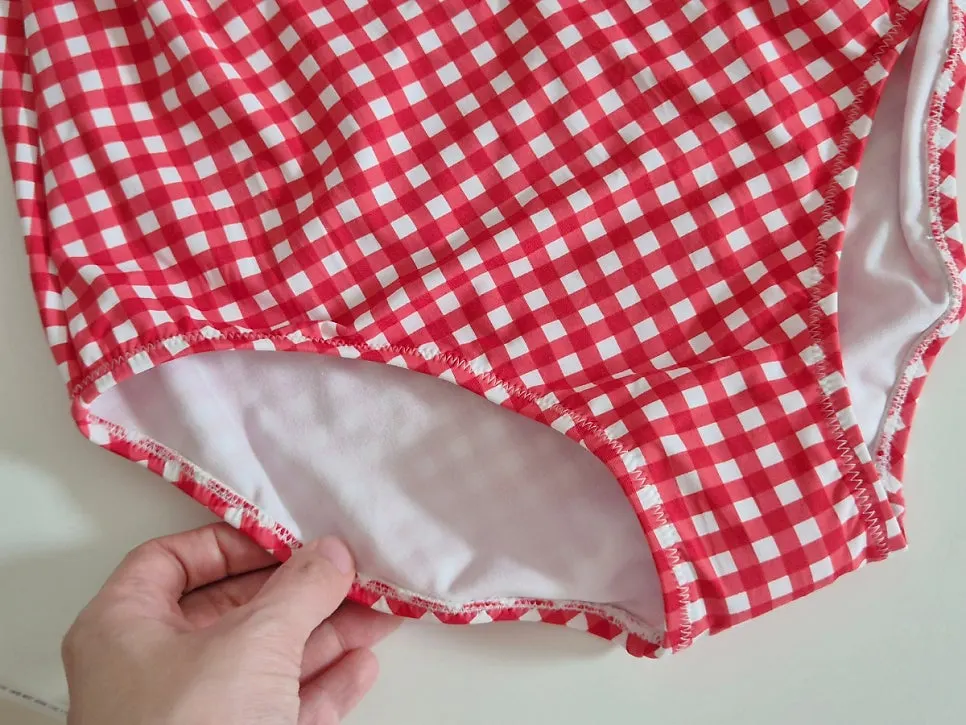 One-piece swimsuit with a tie-up for adjusting the fit