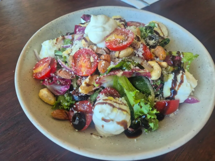 Ricotta cheese salad piled with vegetables and nuts