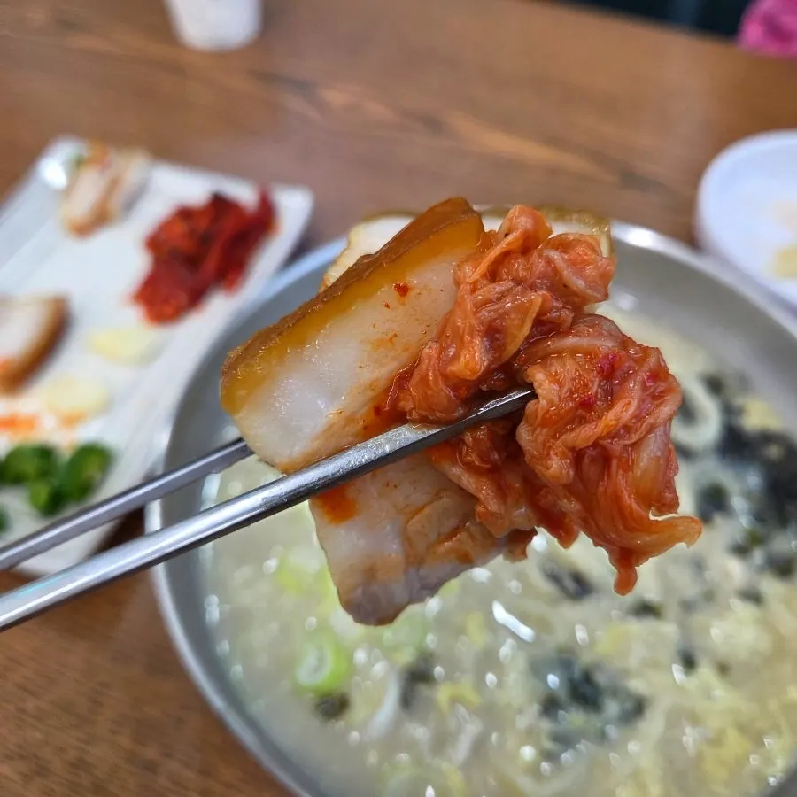 A piece of suyuk dipped in kalguksu broth