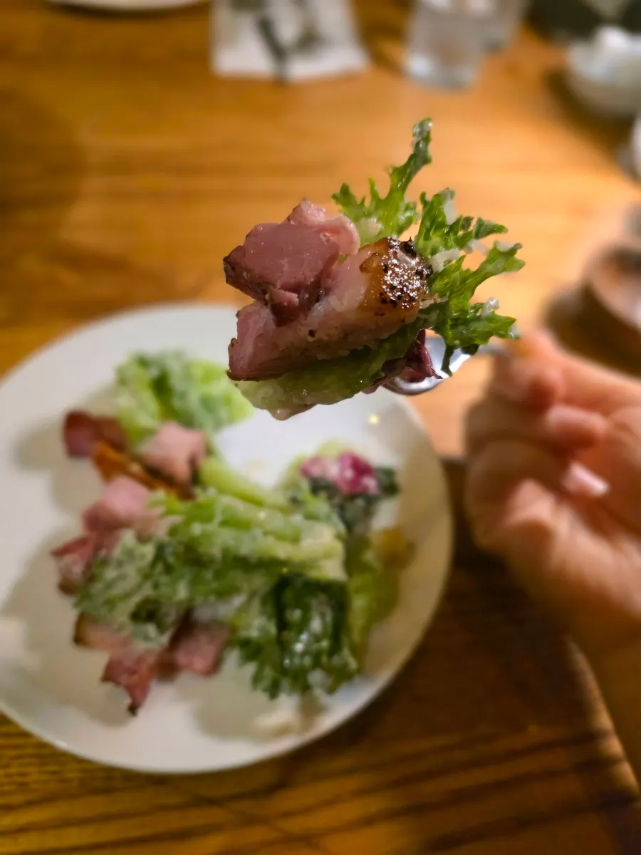 厚切りの手作りベーコンと半熟卵がのったサラダ