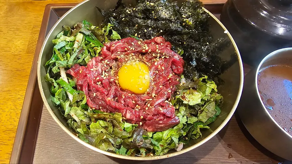 상추와 깻잎, 노른자가 올라간 육회비빔밥