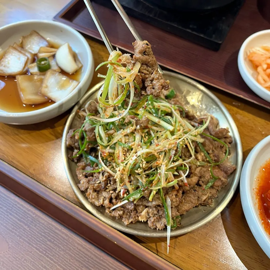 A bite of pork bulgogi with green onion shreds
