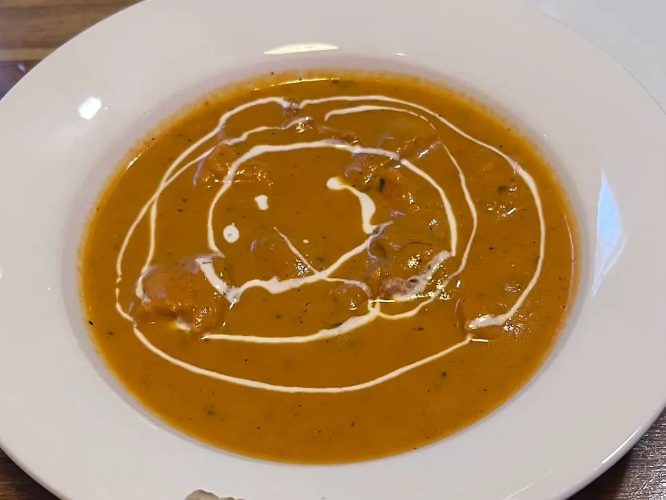 Table set with two curries and honey naan