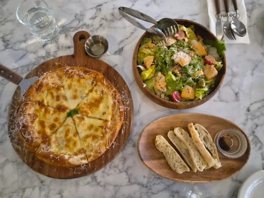 Salad and gorgonzola pizza laid out on the table