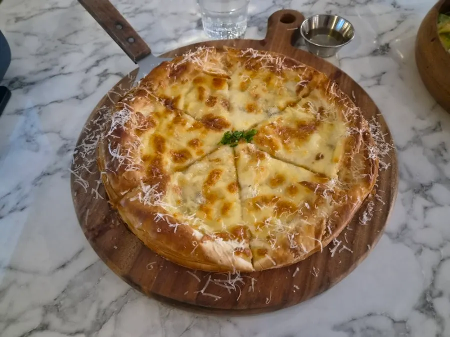 A whole gorgonzola pizza topped thickly with cheese