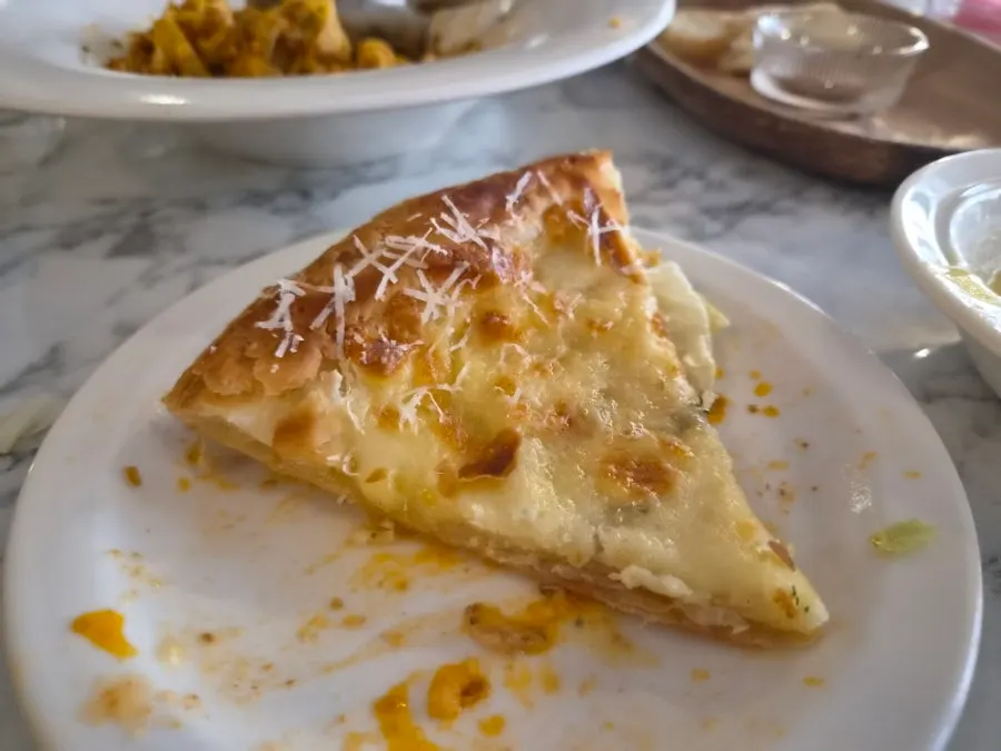 A slice of gorgonzola pizza dipped in honey