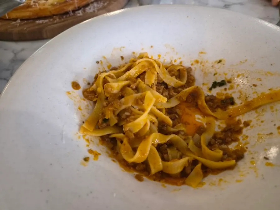 Close-up of fettuccine noodles well soaked in ragu sauce