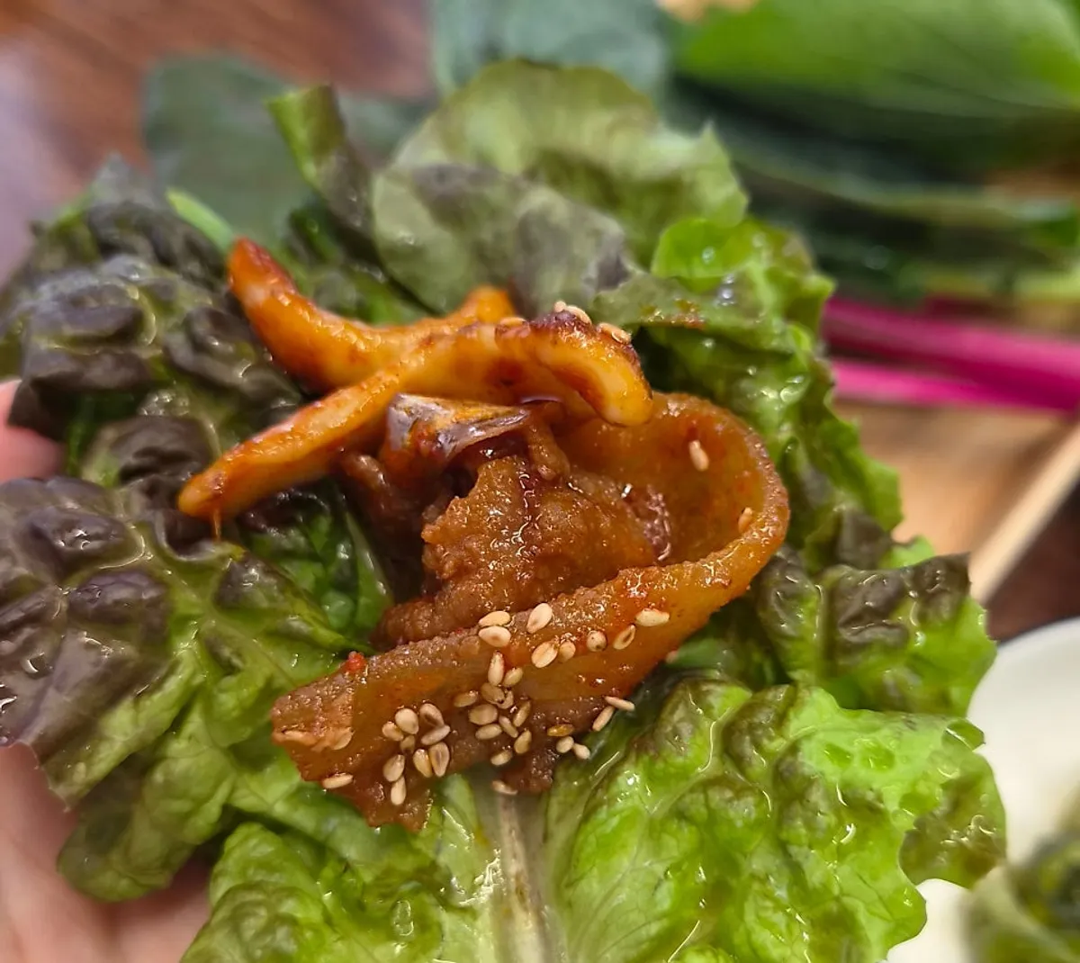 A wrap of pork ssambap in ssam greens