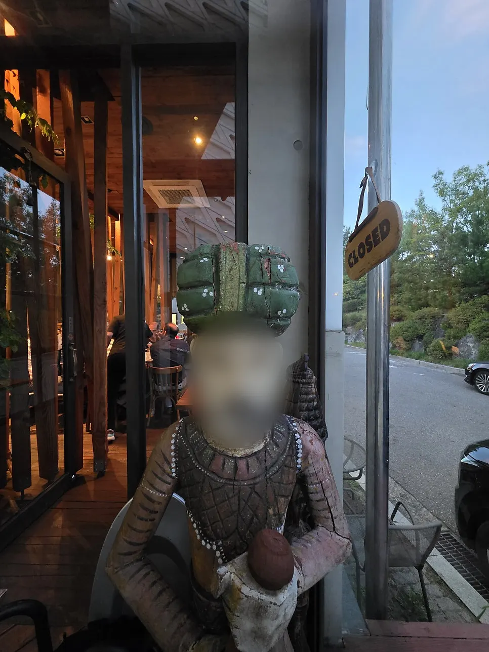 Indian sculpted figure at the entrance with wood-tone interior