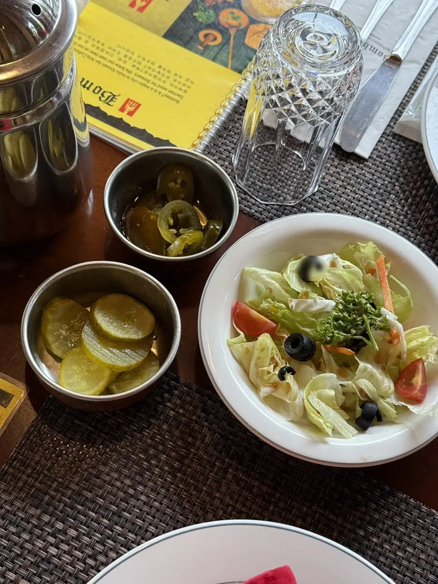 Standard table setting with salad, pickles and jalapeños