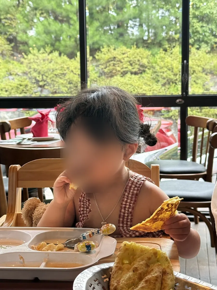 Child's hand grabbing a piece of naan