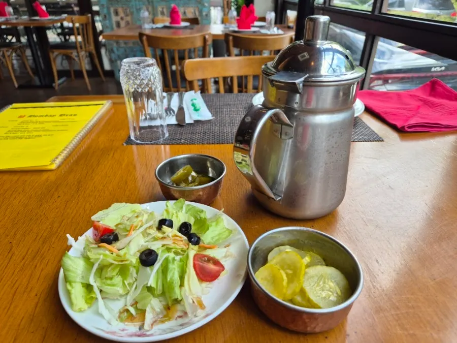 Lettuce salad with cucumber pickles and jalapeños as starter sides