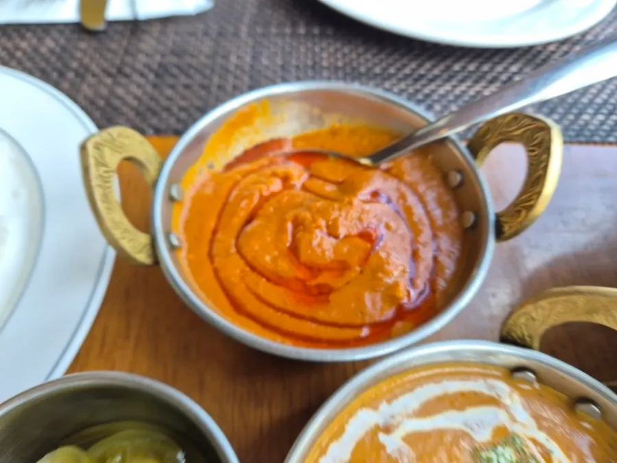 Tearing garlic naan to dip into the curry