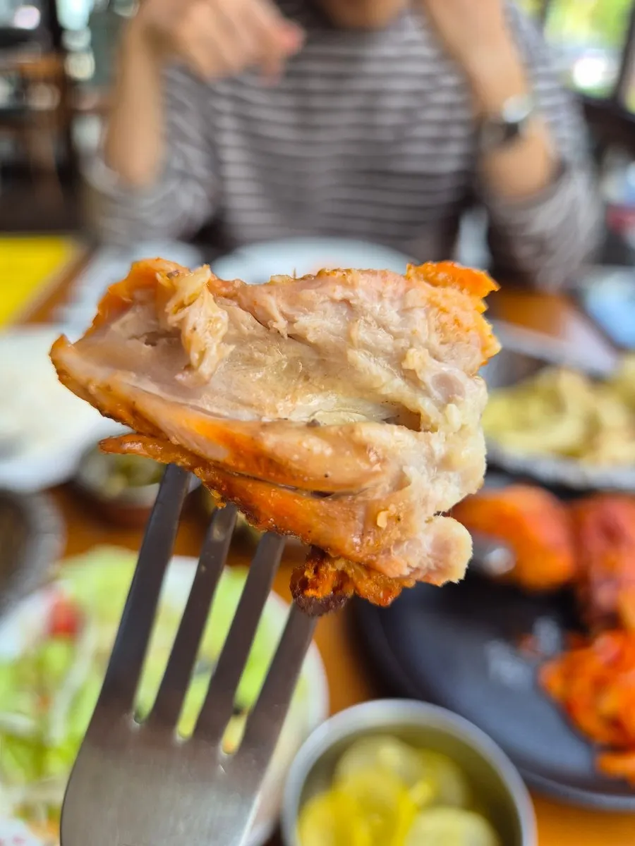Pulling apart the tandoori chicken to show the juicy meat inside