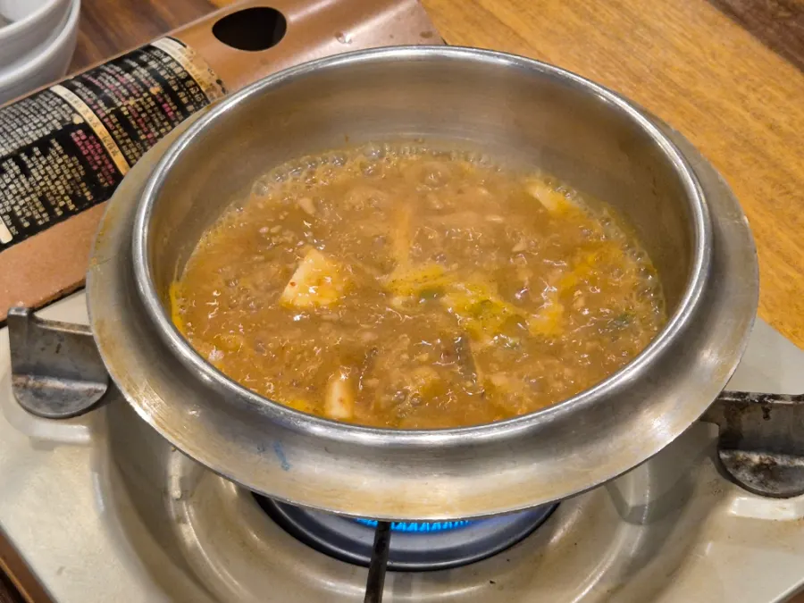 Hot-pot rice with the lid off, surrounded by side dishes