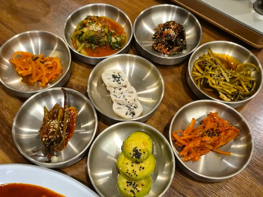 Assorted side dishes including pickled chili peppers