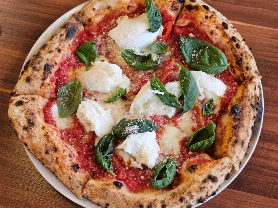 A whole Bufala Margherita pizza fresh out of the wood-fired oven