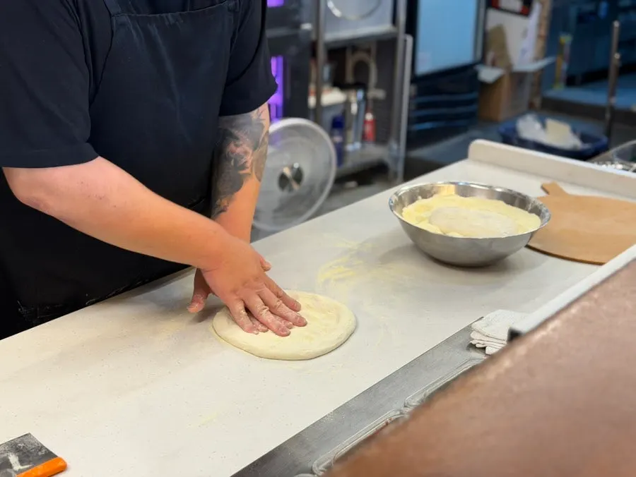 Stretching pizza dough in the open kitchen