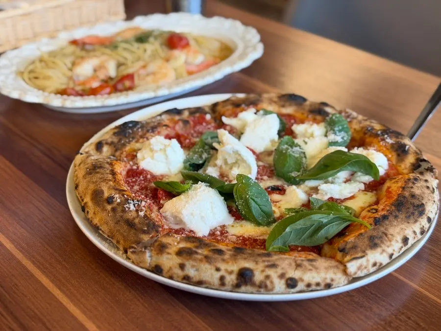 Extra margherita pizza fresh out of the wood-fired oven