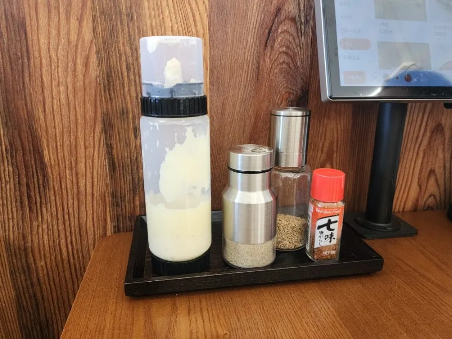 Salad dressing and sesame shichimi pepper on the table