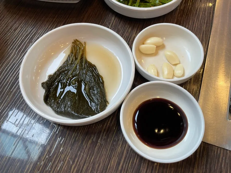 Standard side dishes: chive salad, cabbage salad, lotus root, white kimchi, pickled ginger
