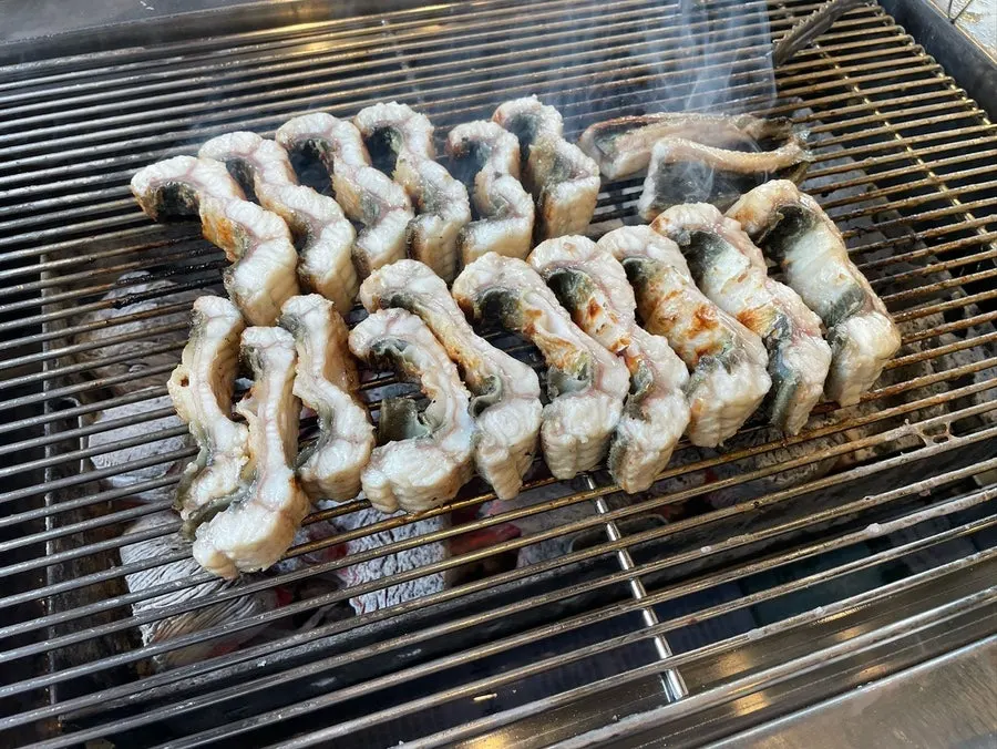 Thick piece of eel meat picked up with chopsticks