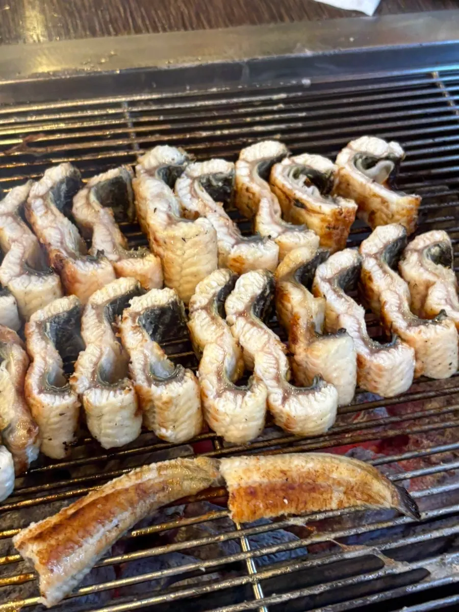 Staff grilling eel on the tabletop grill
