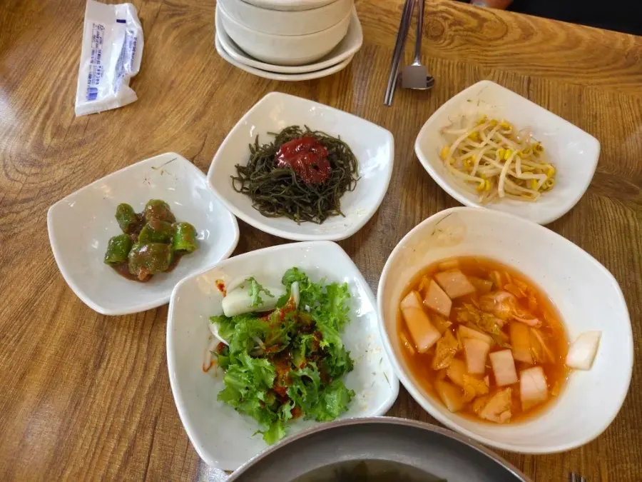 Full table of side dishes served with the okkumi hot-plate set