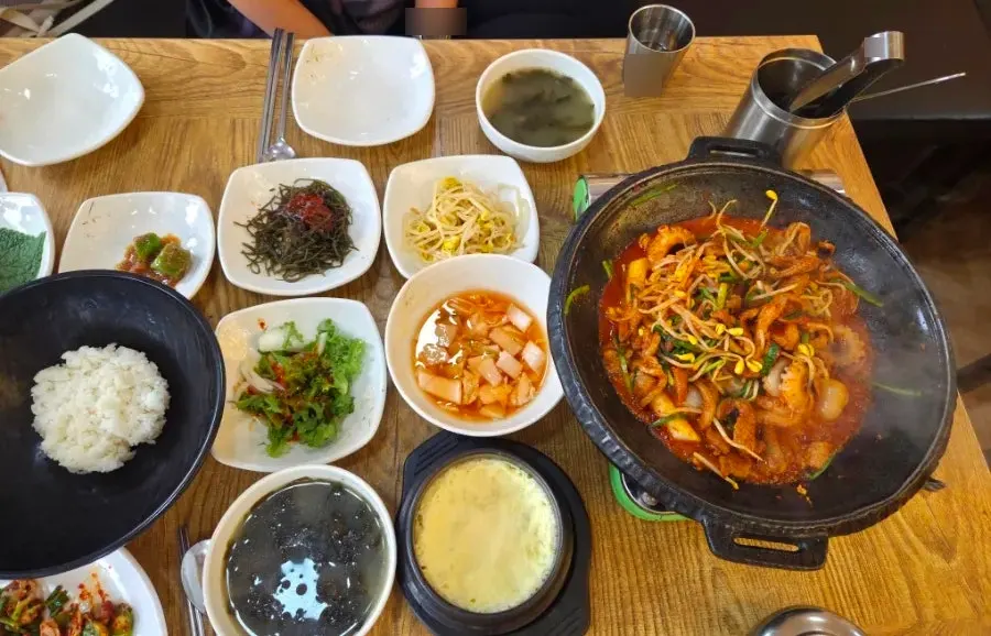 Hot plate of okkumi with mushrooms, duck meat, rice cake, and baby octopus