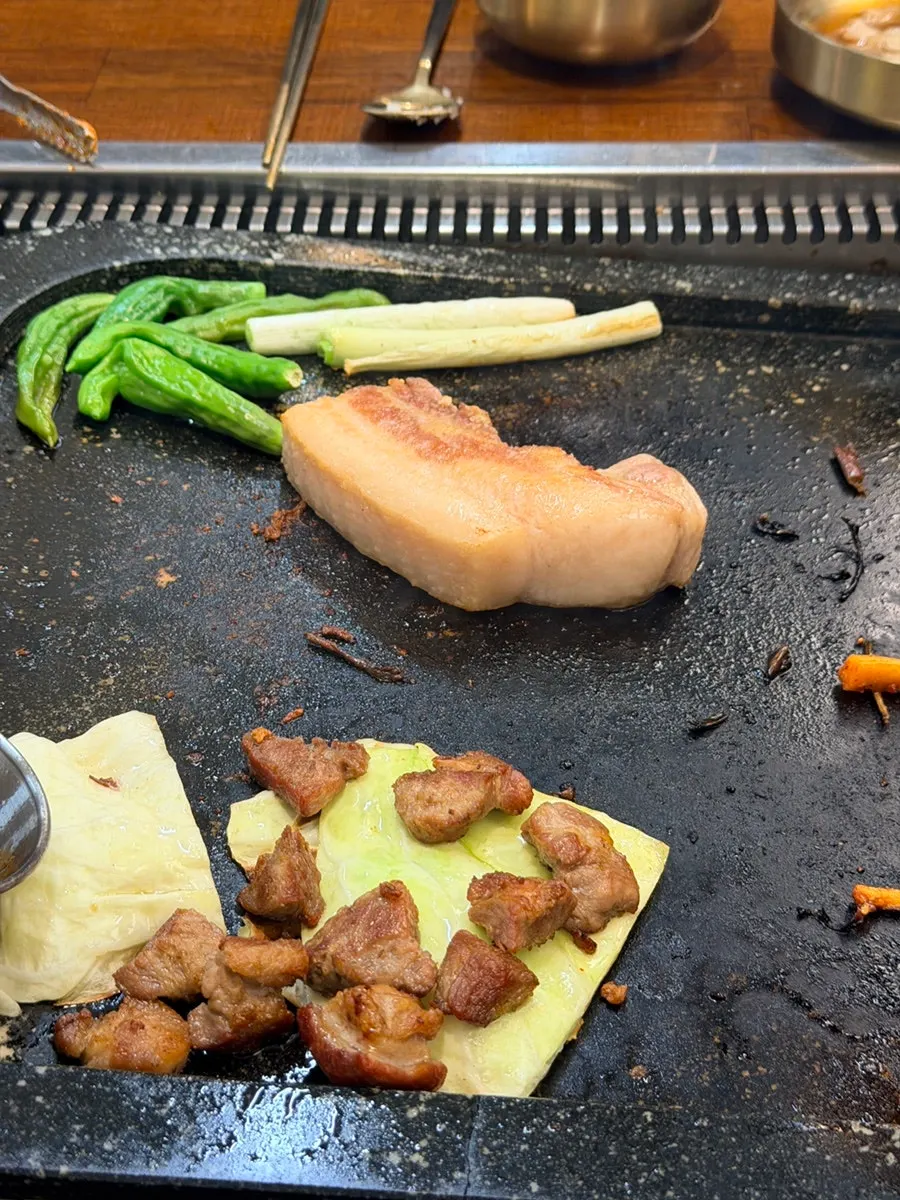 Pork belly cooking on a stone plate