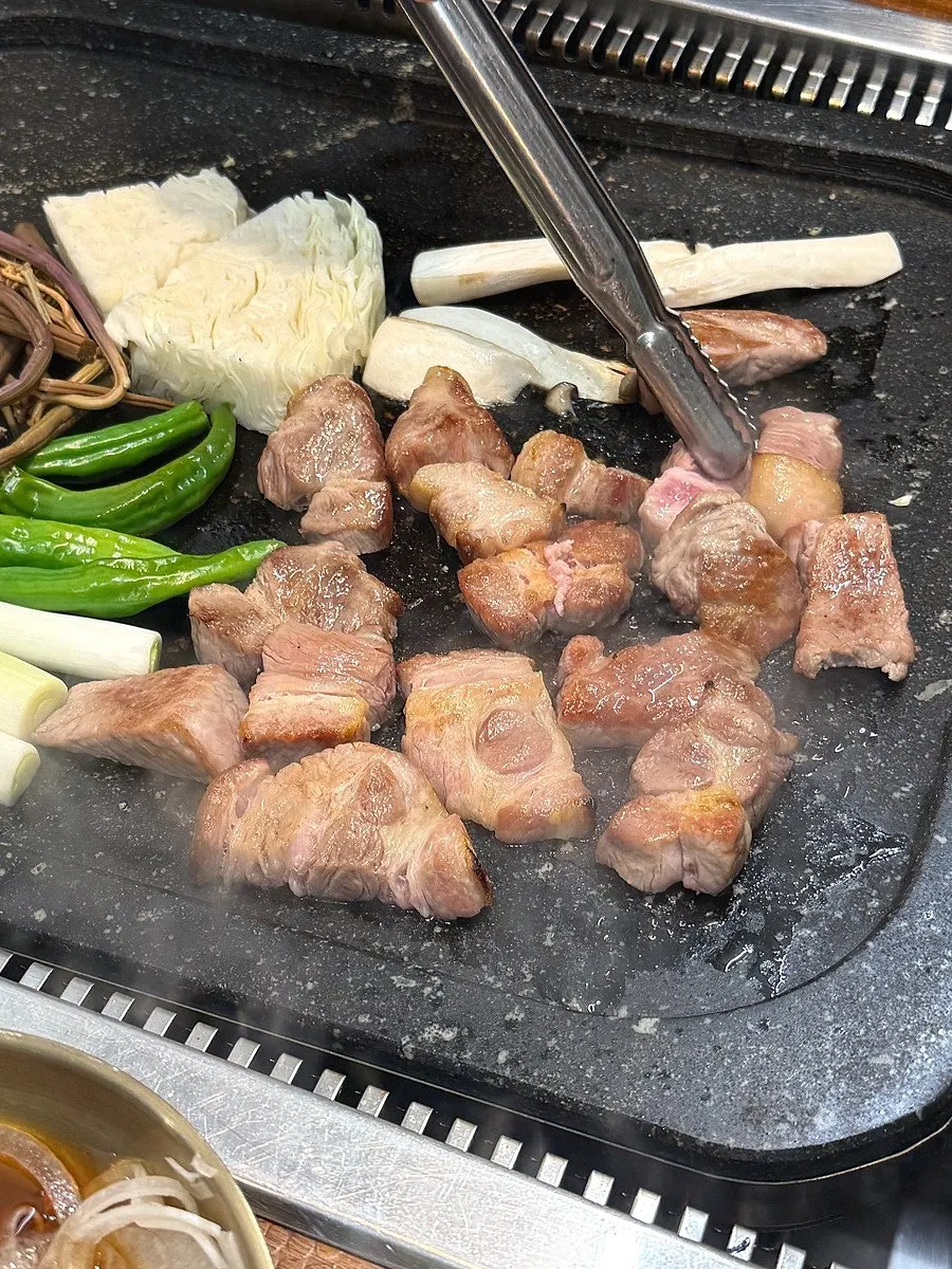 Pork neck grilled together with cabbage, mushrooms, bracken fern, and green onion