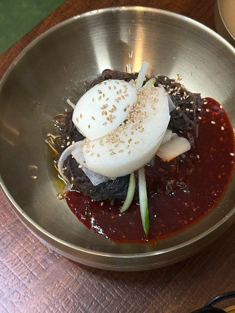 A bite of pork neck with pickled onion