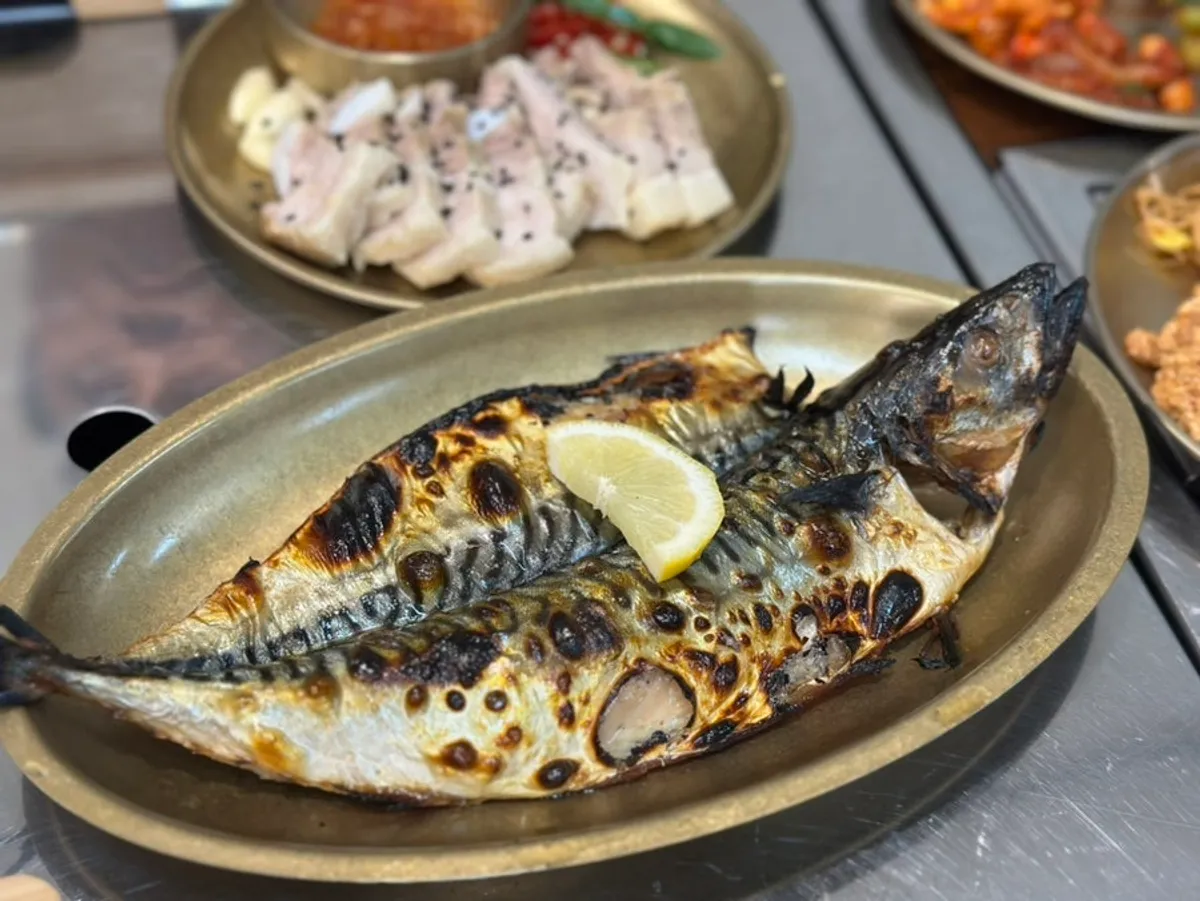 Table spread with the wood-fired mackerel set and charcoal-grilled pork set