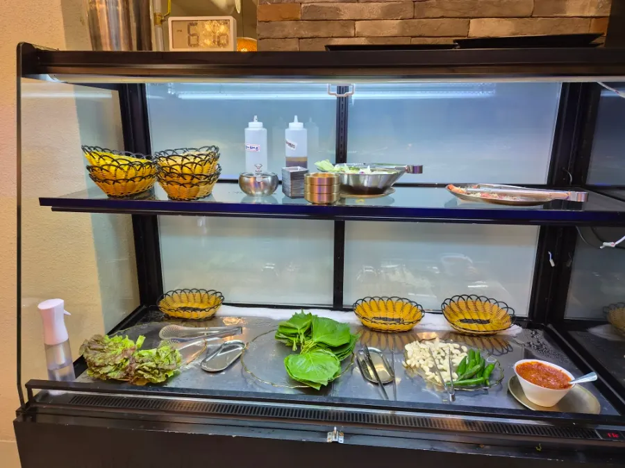 The back section of the self-serve bar with wraps, vegetables and salad