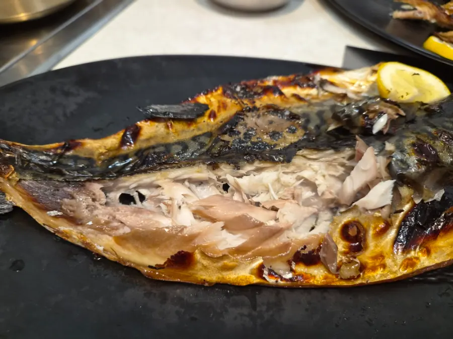 Flaked wood-fired mackerel showing its moist flesh