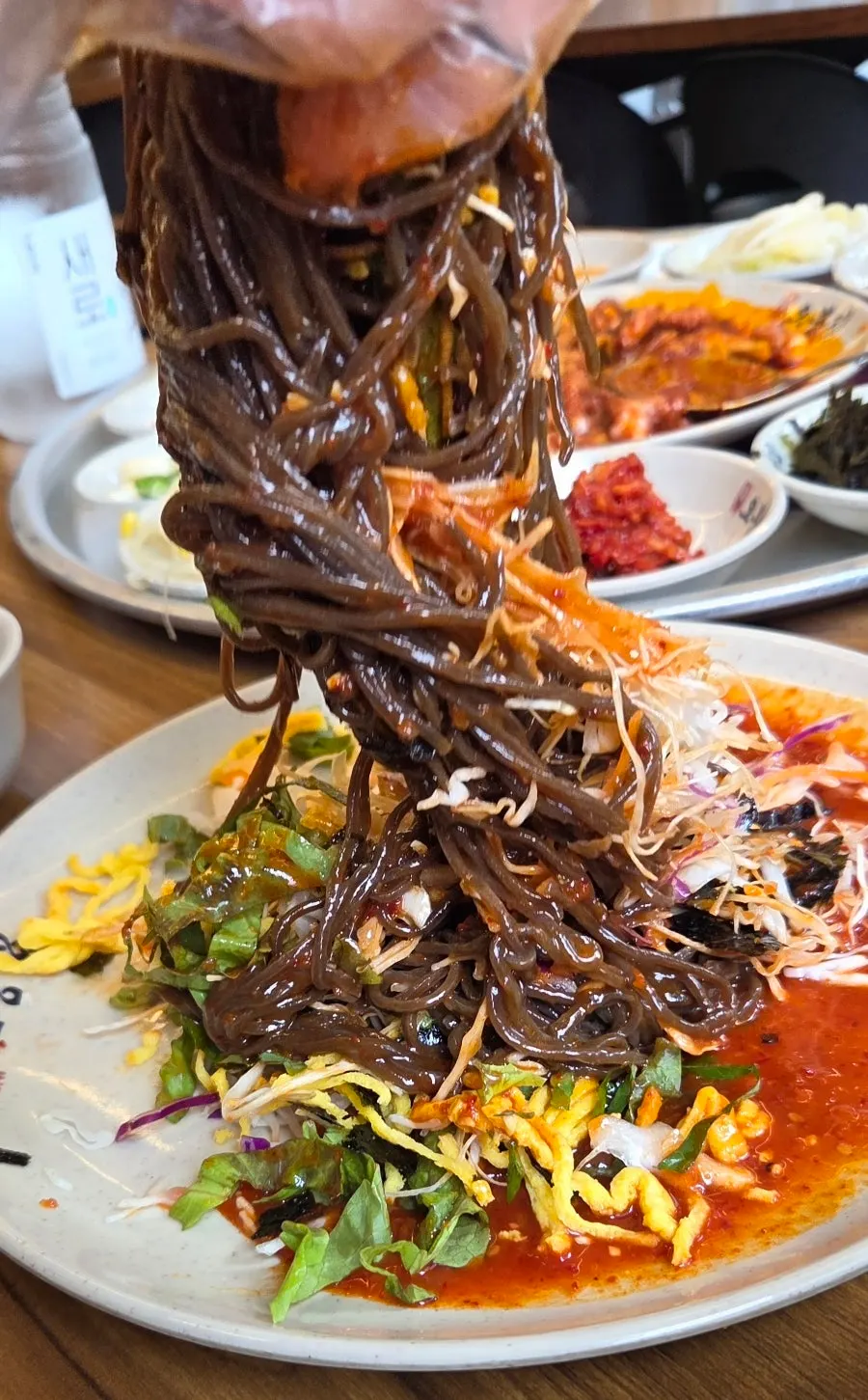 Jaengban makguksu topped with vegetables and egg strips