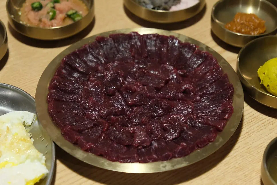 A piece of mungtigi topped with minced garlic