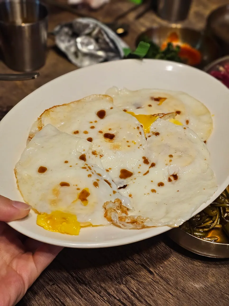 Four fried eggs drizzled with soy sauce