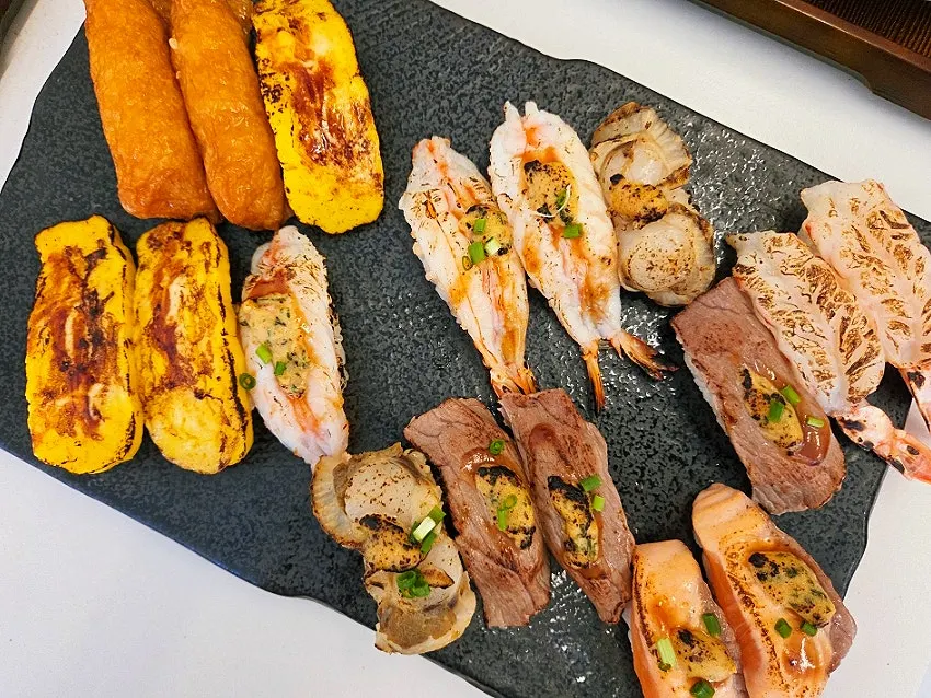 Large plate of garlic sauce flame-seared sushi