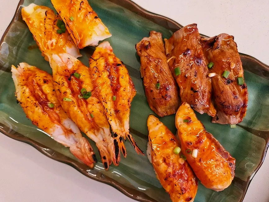 27 pieces of flame-seared sushi served half-and-half sauce