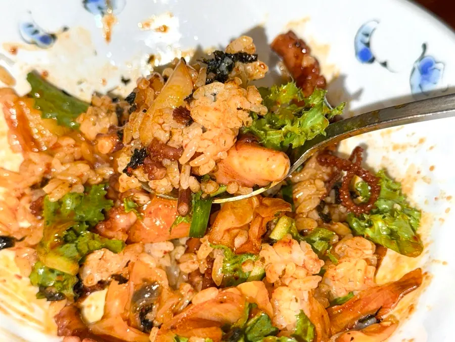 Bowl of rice topped with lettuce and seaweed flakes