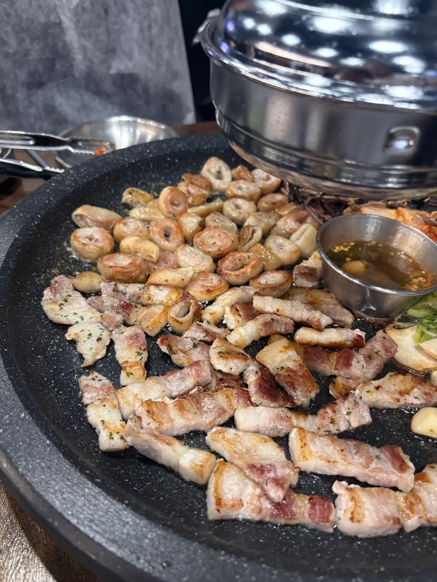 Makchang and pork belly cooking on the stone griddle