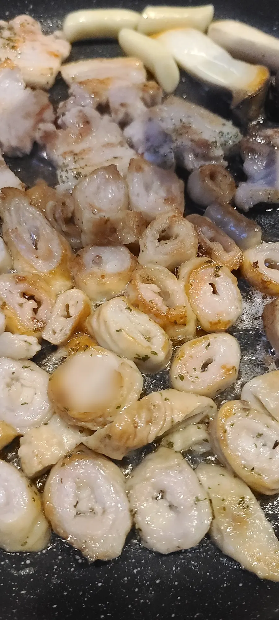 Grill loaded with rice cakes and mushrooms cooking alongside the meat