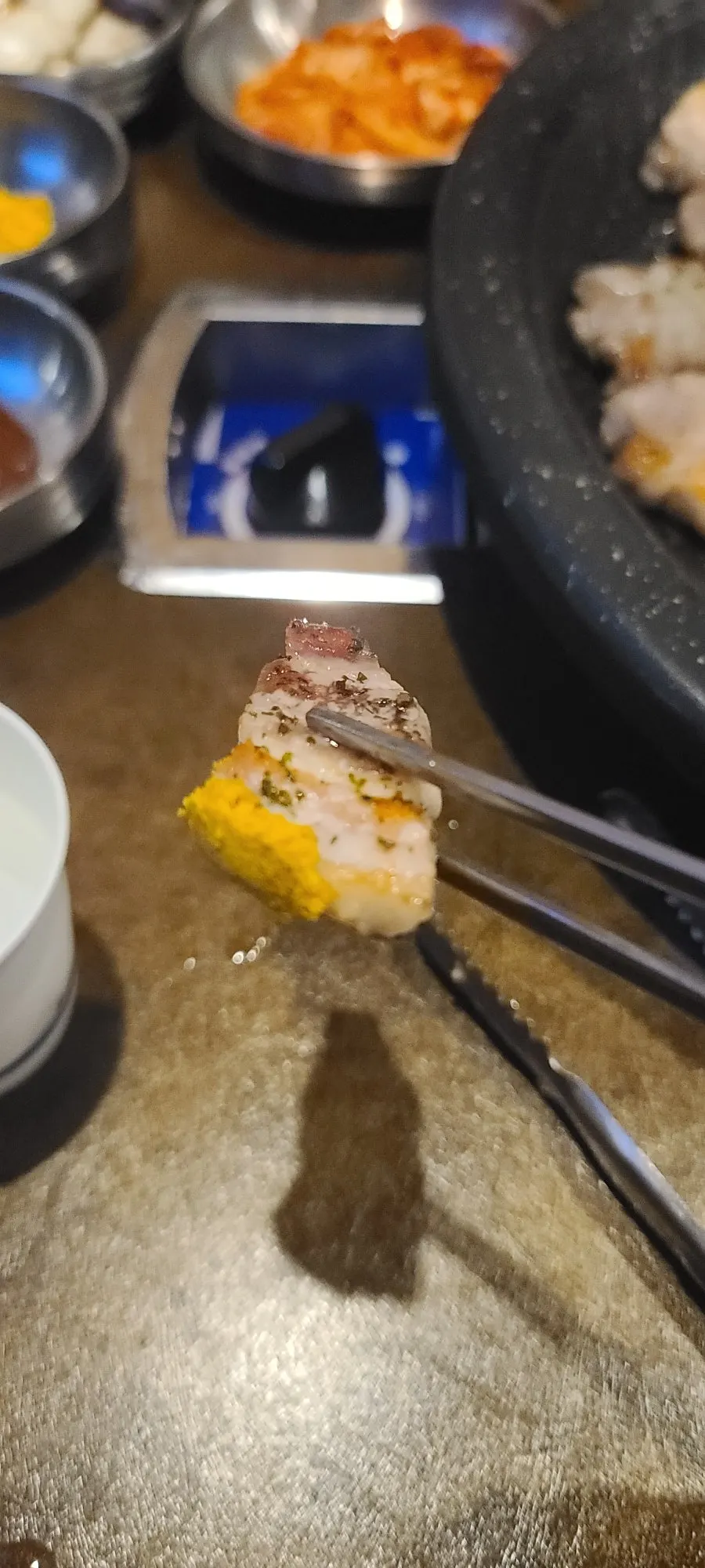A piece of pork belly dipped in salted seafood sauce