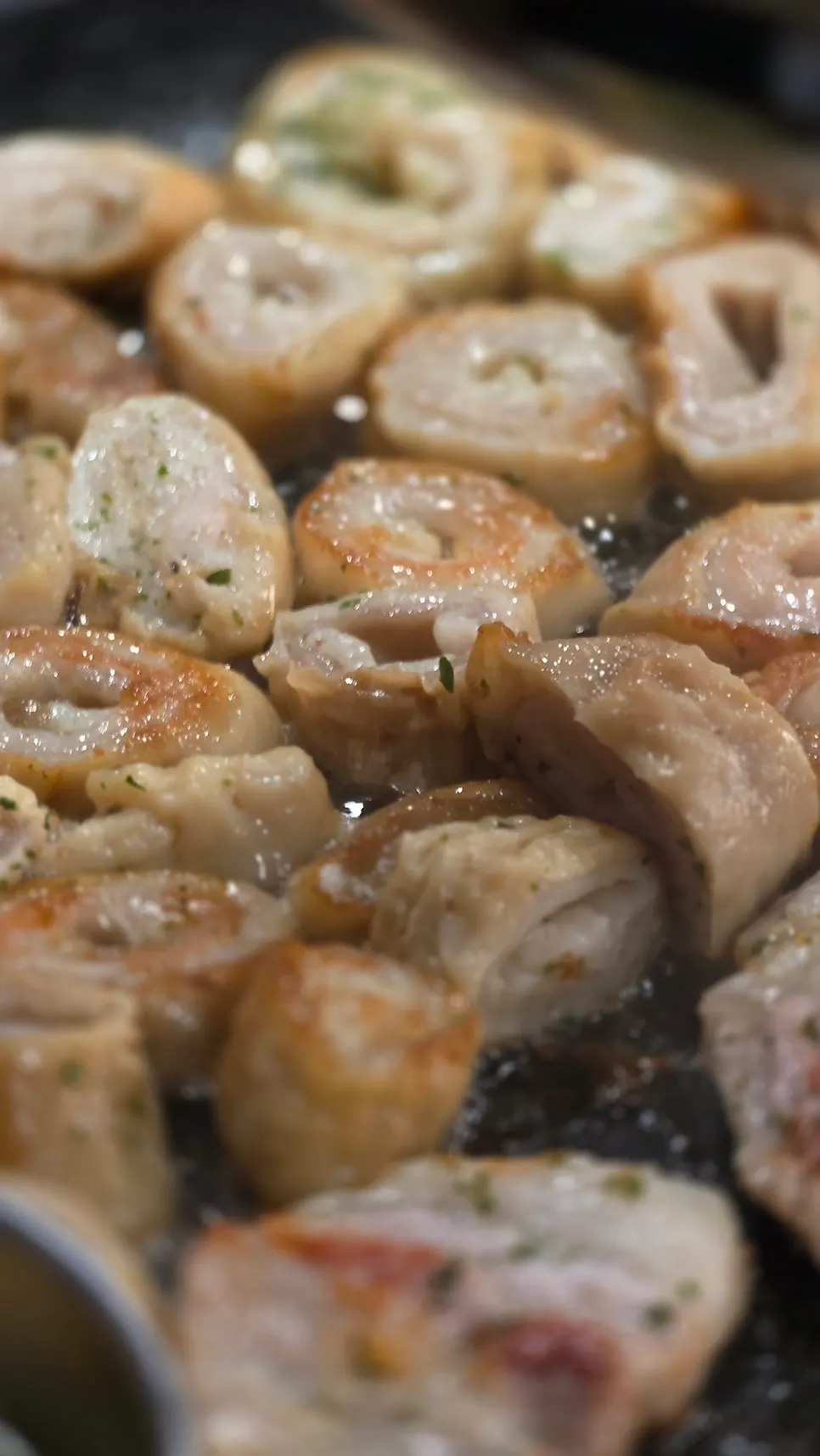 Raw makchang turning golden brown on the grill