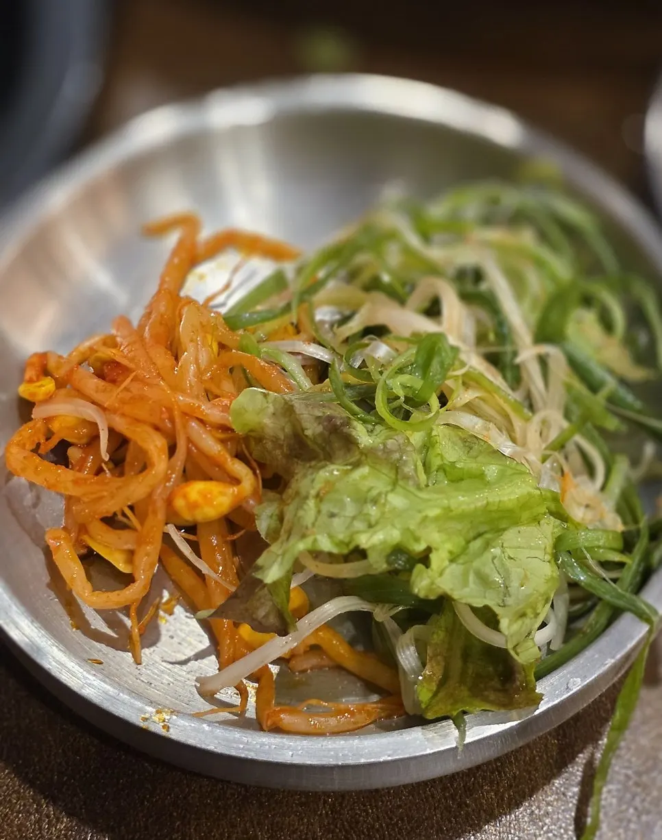 Plate with shredded green onion and seasoned bean sprouts