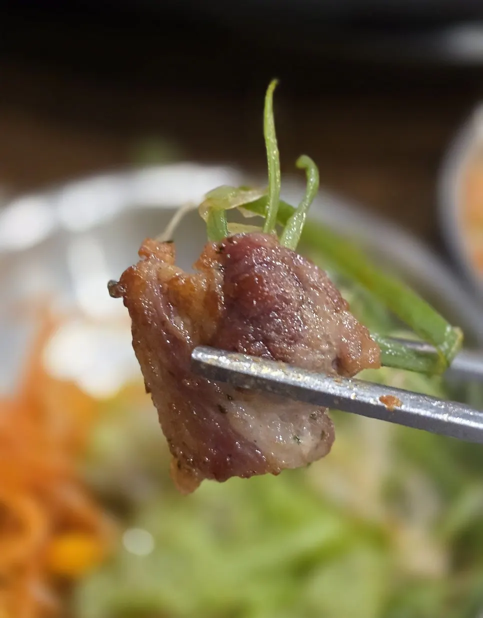 A piece of pork belly topped with shredded green onion