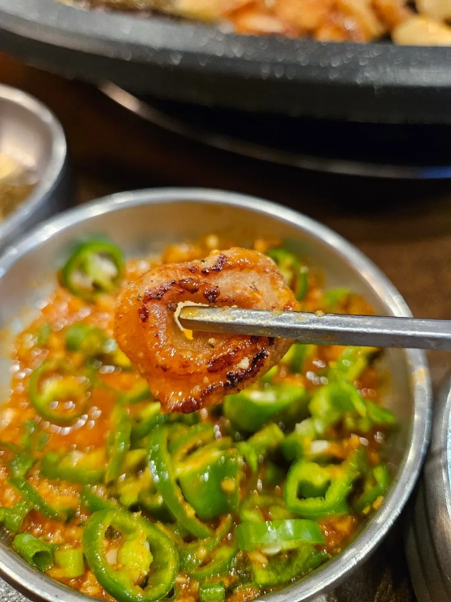 A piece of makchang dipped in makchang sauce